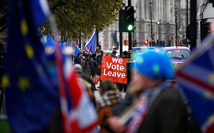 12月4日、英議会は4日、メイ政権が欧州連合（EU）離脱に関する法的助言全容の公表を拒否したことが議会侮辱に当たると認定する動議を賛成多数で可決した。写真は議会まででデモ活動をする離脱賛成派と反対派（2018年　ロイター/HENRY NICHOLLS）