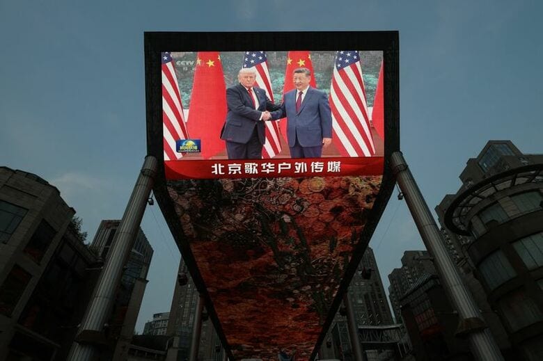 米中首脳会談のニュース映像を映し出す巨大スクリーン。中国・北京で１４日撮影。REUTERS/Tingshu Wang