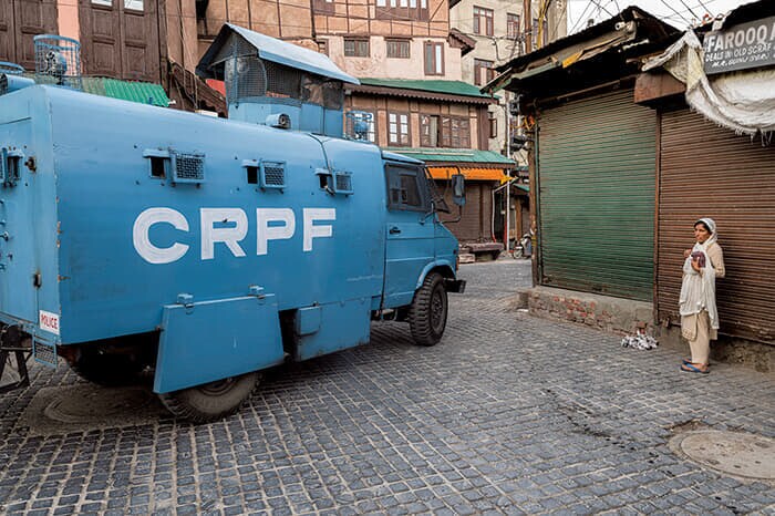 同市の狭い路地を装甲警察車両が走り抜ける