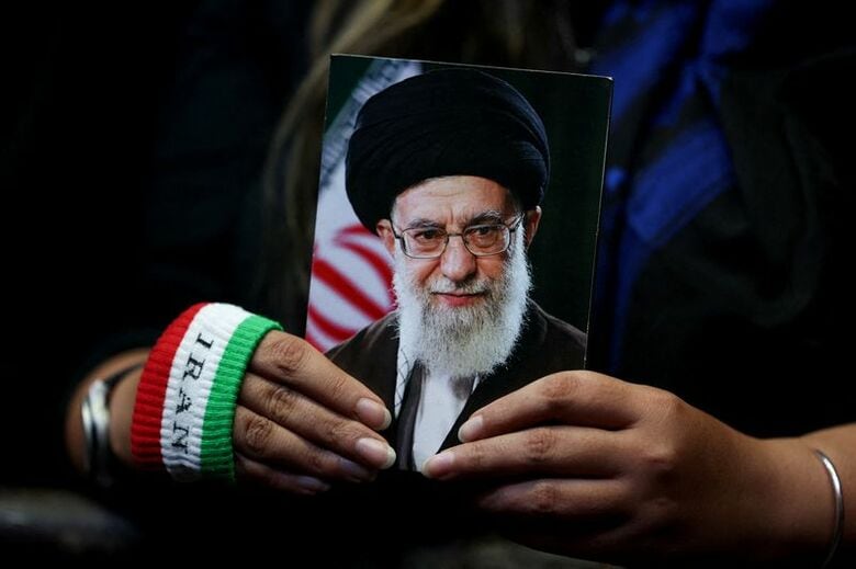 イランの前最高指導者アリ・ハメネイ師の写真を持つ女性。5月29日、イランのテヘランで行われた集会で撮影。Majid Asgaripour/WANA (West Asia News Agency) via REUTERS