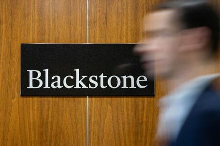 　７月２４日、米大手投資会社ブラックストーンのジョン・グレイ社長兼最高執行責任者（ＣＯＯ）は、新規株式公開（ＩＰＯ）について、過去最高件数を記録した２０２１年以降で最も活発化する展開に備えていると明かした。写真はブラックストーンのロゴと人影。２０２３年１月、ニューヨークの本社で撮影（２０２５年　ロイター/Jeenah Moon）