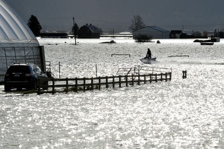 １１月１７日、カナダ西部ブリティッシュコロンビア州は、集中豪雨で発生した洪水と土砂崩れによる被害が拡大する中、非常事態を宣言した。写真は１６日、洪水被害を受けた農場を水上バイクで移動する人（２０２１年　ロイター／Jennifer Gauthier）