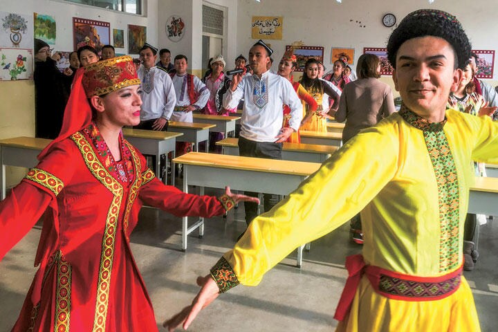 カシュガルの「職業訓練センター」で報道関係者を出迎える収容者（この写真は当局の監視下で撮影された）　BEN BLANCHARDーREUTERS