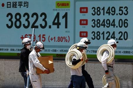 　５月１３日、東京株式市場で日経平均は４日続伸し、３月２６日以来となる３万８０００円台を回復して取引を終えた。写真は同日、都内の株価ボード前で撮影（２０２５年　ロイター/Kim Kyung-Hoon）