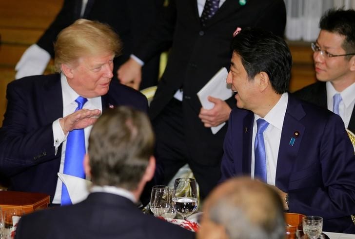 ２月１５日、菅義偉官房長官は午前の記者会見で、１４日夜に行われた日米首脳による電話会談では、北朝鮮の非核化どう実現するか話し合ったことを明らかにした。写真左はトランプ米大統領、右は安倍首相。昨年１１月都内での代表撮影（２０１８年／ロイター）