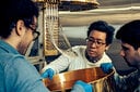 量子プロセッサを極低温まで冷却するための磁気シールドを取り付けるチョウ（中央）らIBMの研究者　VICTORIA WILL