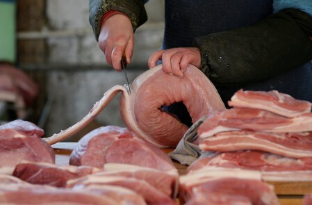 　２０１６年３月、北京の市場で豚肉を切る精肉店員（２０１８年　ロイター/Jason Lee）