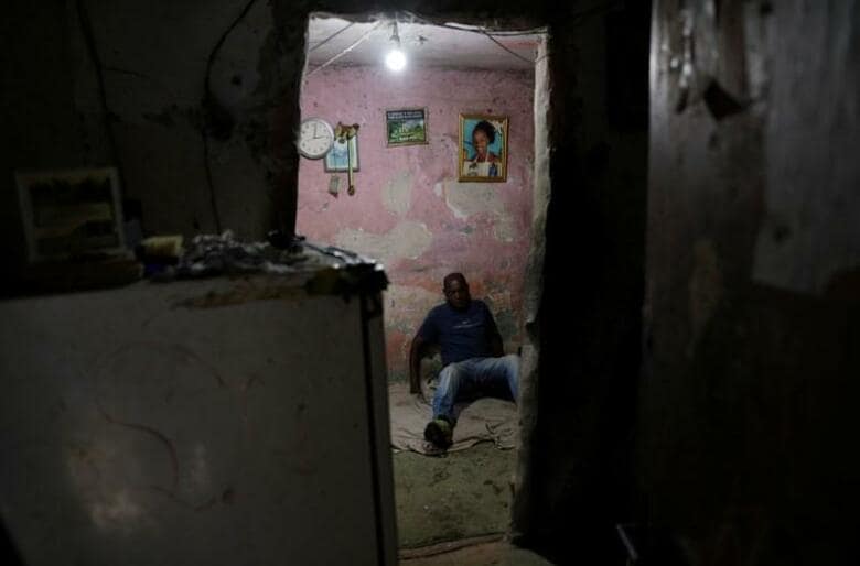 ブラジル第2の都市、リオデジャネイロにいくつも存在するスラム街（ファベーラ）の人々が、新型コロナウイルスの襲来におびえながら暮らしている。写真はスラム街「シティ・オブ・ゴッド」の自宅ですごす男性。22日撮影（2020年　ロイター/Ricardo Moraes）