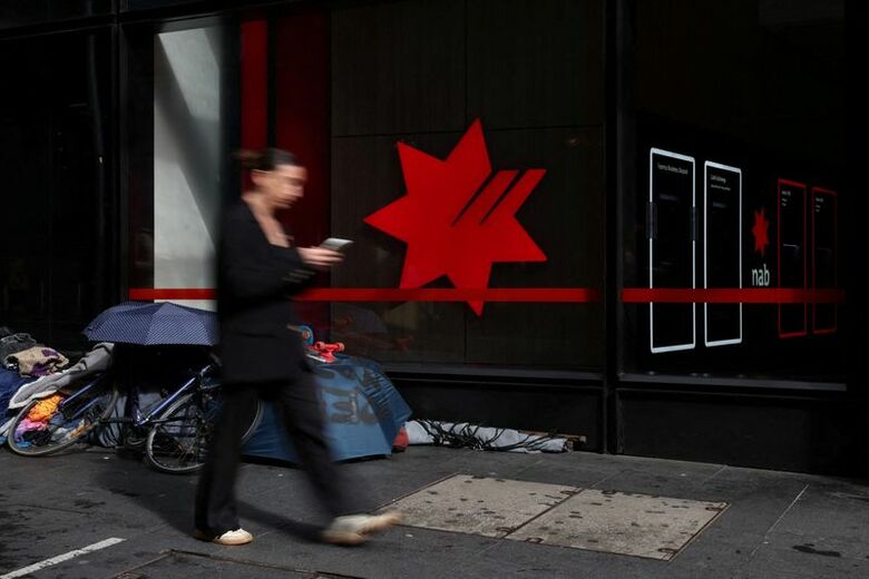 豪大手行ナショナル・オーストラリア銀行（ＮＡＢ）支店前を通り過ぎる女性。2025年8月、シドニーで撮影。REUTERS/Hollie Adams