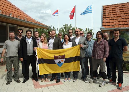　南東欧のバルカン半島を流れるドナウ川は１９世紀に直線的な流れに変わり、かつてクロアチアの一部だった地域がセルビア側に移った一方、セルビアの一部だった全長７キロの中州、ゴルニャ・シガ島はクロアチアの対岸に手を伸ばせば届く近さになった。写真はリベルランドの旗を持つイェドリチカ氏と市民権を得た人々。２０１５年５月、セルビア・ボイボディナ自治州バッキ・モノストル村で撮影（２０２３年　ロイター/Antonio Bronic）