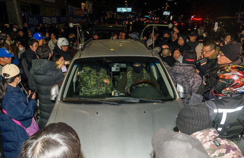 韓国、戒厳令を受けて国会に突入して活動を止めようとする軍隊の車両と抵抗する国民（12月3日、ソウル）Kim Jae-Hwan / SOPA Images via Reuters Connect