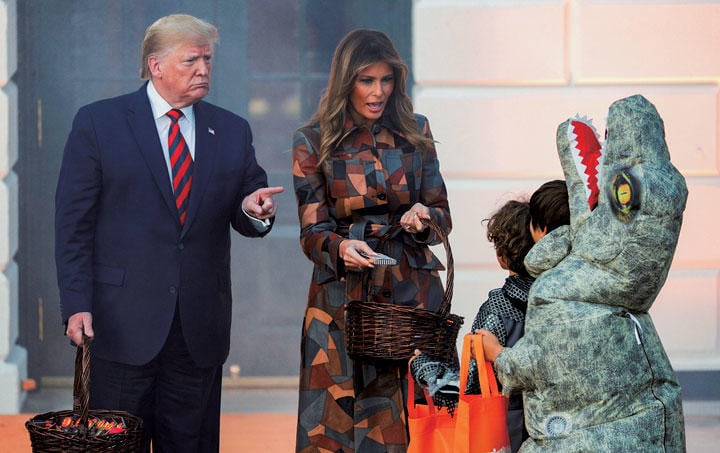 メラニア夫人と一緒に子供たちにお菓子を渡すトランプ　TOM BRENNER-REUTERS