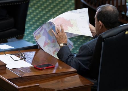 　米テキサス州議会上院は２３日未明、来年１１月の中間選挙に向け、共和党に有利な選挙区割り案を可決した。写真は同州議会で区割り再編地図を確認するピート・フローレス上院議員（共和党）。テキサス州オースティンで２２日撮影（２０２５年　ロイター/Nuri Vallbona）