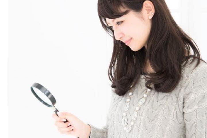 ルーペを持つ女性