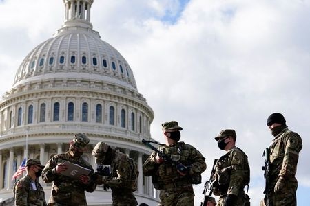　バイデン米次期大統領の就任式を前に、トランプ大統領の支持者や過激派団体が抗議活動を行うとの懸念があるなか、首都ワシントンと全米５０州の州都にある州議会議事堂周辺では１７日、厳戒態勢が敷かれた。ただ、デモ隊はこれまでのところごく少数にとどまっている。写真は議事堂周辺の州兵（２０２１年　ロイター/Erin Scott）