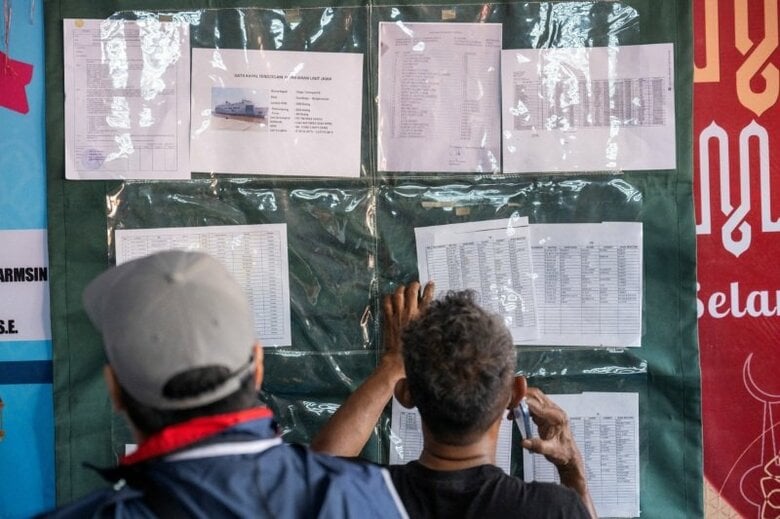 写真は転覆した旅客船の乗客名簿を確認する人々。9月13日、インドネシア南カリマンタン州バンジャルマシンのトリサクティ港で撮影。REUTERS