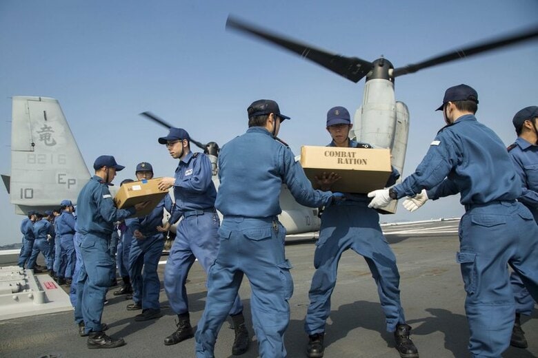 ４月２３日、自民、公明両党は熊本地震の被災状況が深刻化していることを踏まえ、２０１６年度補正予算案を６月１日までの今国会で処理する検討に入った。写真は救援物資を米軍機に運ぶ自衛隊員ら。熊本沖で１９日撮影。米海軍提供(２０１６年　ロイター)