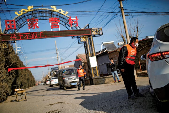 新型肺炎を警戒して町への部外者の侵入を妨げる市民（北京郊外）　CARLOS GARCIA RAWLINS-REUTERS