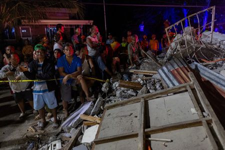 　１０月２日、フィリピン当局は、地震に見舞われたセブ州での捜索・救助活動は終了したと発表した。写真はボゴ市で救助活動を見守る住民ら。１日撮影（２０２５年　ロイター/Eloisa Lopez）