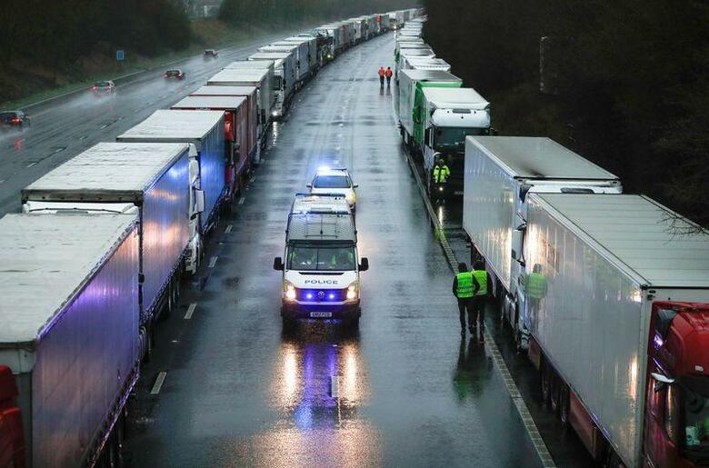英小売業界団体は２３日、英・欧州間の物流の大動脈であるドーバー海峡で続く物資輸送の混乱が解消するまで、英国内で野菜や果物などの青果食品が不足するリスクがあると警告した。写真はトラックで渋滞する英アシュフォードの道路。２３日撮影（２０２０年　ロイター/PETER NICHOLLS）