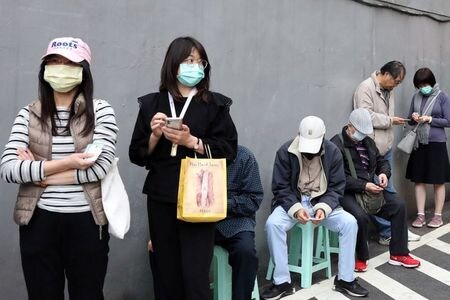 　台湾当局は１８日、新型コロナウイルスの感染拡大を受け、大半の外国人の入境を禁止すると発表した。写真はマスクを求める行列。台北で撮影（２０２０年　ロイター/Ann Wang）