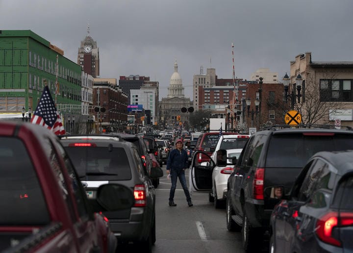 外出禁止令延長に反発し、ミシガン州ランシングの州議事堂に向かって車で列を作る抗議デモ（4月15日）　Seth Herald-REUTERS