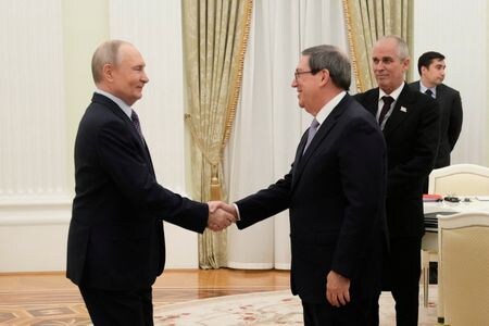 キューバのロドリゲス外相と握手を交わすロシアのプーチン大統領。ロシア大統領府（クレムリン）で18日撮影。Pavel Bednyakov/Pool via REUTERS