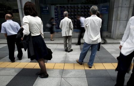 　５月２２日の東京株式市場で、東証１部の時価総額が５９１兆３００７億円となり、終値ベースで過去最高となった。写真は株価ボードを眺める人々、都内で２０日撮影（２０１５年　ロイター/Yuya Shino）