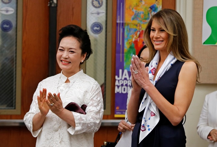 7日、現地の芸術学校を訪問した彭麗媛夫人（左）とメラニア夫人（右）　Joe Skipper-REUTERS