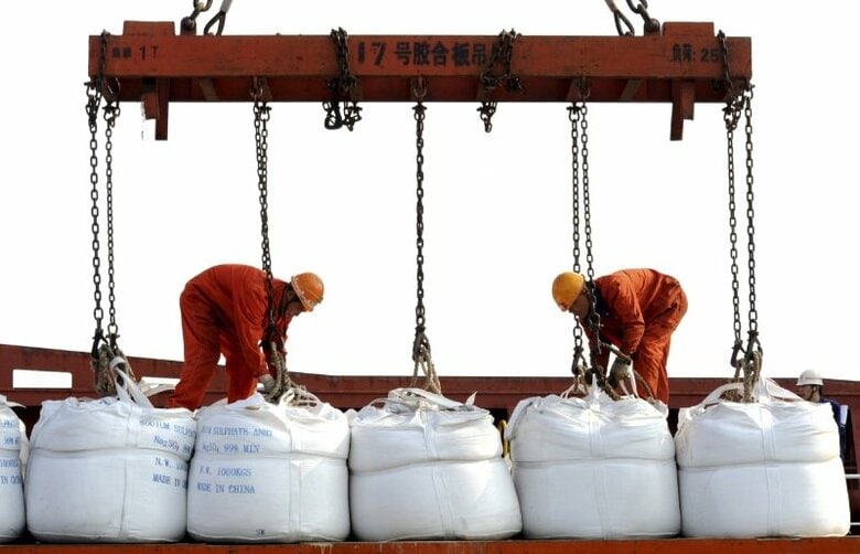 ２０１４年５月、中国江蘇省連雲港の港で輸出用の化学薬品の袋を船に積み込む作業員。提供写真。REUTERS/China Daily