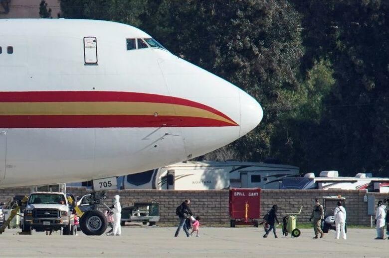 中国での新型コロナウイルスによる肺炎の感染拡大を受け、湖北省武漢市から退避した米国人195人を乗せた米政府のチャーター機が29日、カリフォルニア州ロサンゼルス近郊のマーチ空軍基地に到着した。写真はチャーター機で帰国した人々。同基地で29日撮影（2020年　ロイター／Mike Blake）