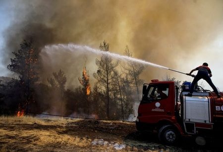 　トルコのエルドアン大統領は４日、南部沿岸地域で１週間以上続いている山火事について、同国史上最悪の規模だと述べた。４日には南西部にある発電所にも火が燃え移った。写真はマルマリスで消火活動を行う消防士。１日撮影（２０２１年　ロイター／UMIT BEKTAS）