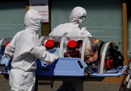 　８月１４日、新型コロナウイルスの感染者数が増加する中、韓国で１４日、政府の医学生増員計画に反対する医師らがストライキを決行。少なくとも全国でおよそ２５％の医療機関が休診となった。写真は新型コロナウイルスの感染が疑われる患者を搬送する医療従事者。テグで３月撮影（２０２０年　ロイター／Kim Kyung-Hoon）