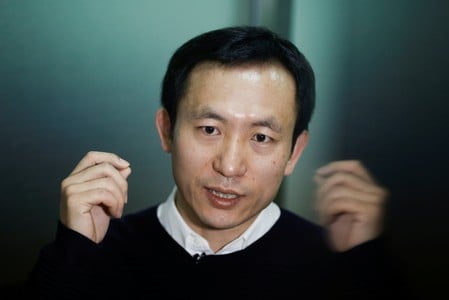 　３月１０日、北京郊外の幹線道路に設けられた検問所では、地元警察官が新しいセキュリティツールを試している。写真は運転者の顔の特徴と車のナンバープレートを読み取り、即座に犯罪容疑者のデータベースと照合する「スマートメガネ」を製造したＬＬビジョンのWu Fei ＣＥＯ。２月撮影（２０１８年　ロイター/Thomas Peter）
