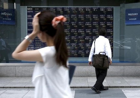 　６月１４日、前場の東京株式市場で、日経平均株価は前日比２０円３４銭高の１万９９１９円０９銭となり小反発した。写真は株価ボードを眺める男性、都内で２０１５年６月撮影（２０１７年　ロイター/Issei Kato）