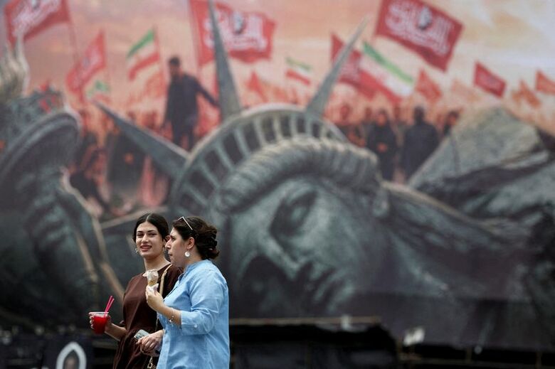 8月3日、テヘランで反米の看板の前を通り過ぎる人々。Majid Asgaripour/WANA (West Asia News Agency) via REUTERS