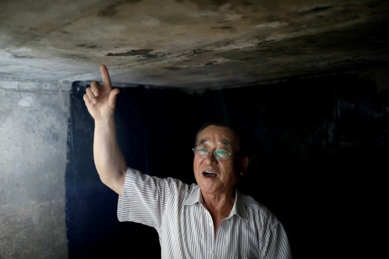 　７月２６日、休戦から６４年を２７日に迎えた朝鮮戦争で休戦協定が協議された板門店への玄関口である韓国最北端の坡州市では、北朝鮮による大陸間弾道ミサイルの発射実験で高まっている緊張などみじんも感じられない。写真は、自分で造った地下シェルターを案内するWoo Jong-ilさん。同市で１４日撮影（２０１７年　ロイター/Kim Hong-Ji）