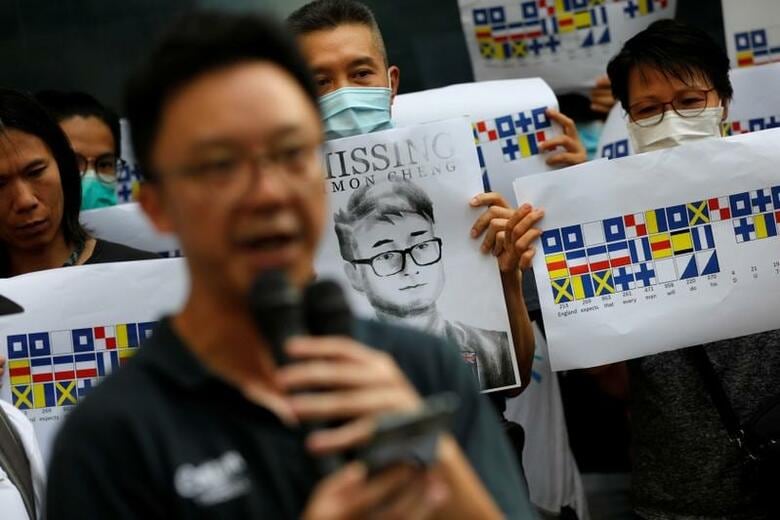 香港の英領事館職員として中国当局に身柄を拘束され、その後釈放されたサイモン・チェン氏が、拘留中の状況を米ウォールストリート・ジャーナル（WSJ）紙と英BBCに明らかにした。写真はチェン氏の似顔絵が描かれたポスターを持つデモ参加者ら。香港で8月21日撮影（2019年　ロイター/Willy Kurniawan）