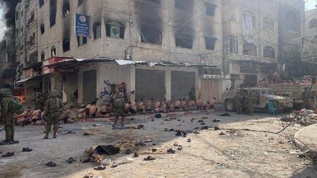 イスラム組織ハマスの当局者は８日、パレスチナ自治区ガザで拘束されたとされる数十人のパレスチナ人男性が下着姿で路上に並ばされている画像がソーシャル・メディアで拡散されたことを受け、イスラエル軍は「罪のない民間人に対する凶悪犯罪」を行っていると非難した。写真は、ガザ地区北部でイスラエル兵が監視する中、道路に下着姿で座る拘束されたパレスチナ人男性ら。写真はロイターが１２月８日に取得。２０２３年　ロイター／THIS IMAGE HAS BEEN SUPPLIED BY A THIRD PARTY）