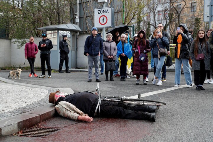 チェコ・プラハのロシア大使館前でロシア軍によるブチャの民間人殺害を模して抗議する人（4月9日）　David W Cerny-REUTERS