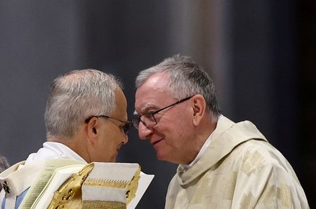 　２月１７日、バチカンの最高外交責任者である教皇庁国務省長官のパロリン枢機卿は、トランプ米大統領が主導する「平和評議会」には参加しないと表明し、危機的状況には国連が対応すべきだと付け加えた。写真は、サン・ピエトロ大聖堂で行われた聖座ジュビリーミサ中の教皇レオ１４世（左）とパロリン枢機卿（右）。バチカンで２０２５年６月撮影（２０２６年　ロイター/Yara Nardi）