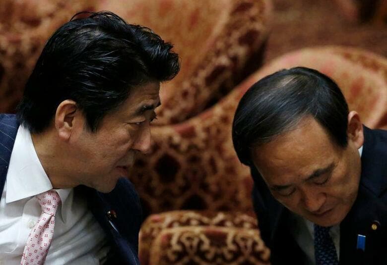 安倍晋三首相(65)の右腕として戦後最長の政権を支えてきた菅義偉官房長官(71)が、次期総理の座を手にする最短距離に浮上してきた。写真は国会の議場内で話す安倍首相(左)と菅官房長官。2014年2月、東京で撮影(2020年　ロイター/Yuya Shino)