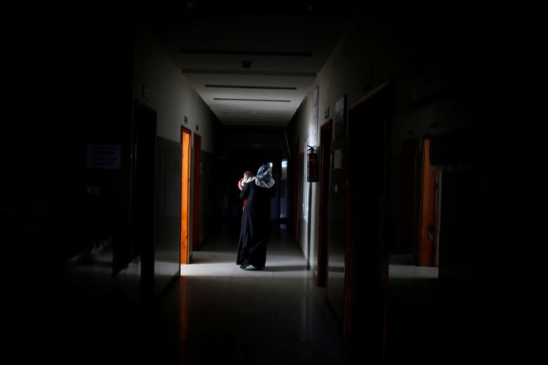 2018年2月6日、ガザの病院に病気の子を運び込むパレスチナ人女性　Mohammed Salem-REUTERS