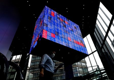 　８月１日、午前の東京株式市場で日経平均は、前営業日比１００７円５８銭安の３万８０９４円２４銭と、急反落した。写真は株価ボードの下を歩く男性。都内で２０２２年６月撮影（２０２４　ロイター／Issei Kato）