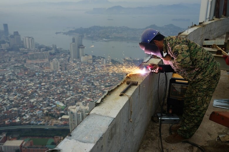 ７月２５日、中国南部の港湾都市、厦門（アモイ）の市職員を勤める２６歳のYang Xiaodaoさんは、２ベッドルームのマンションを夫と３０年ローンで購入したことが、人生で最大の失敗だったと悔やんでいる。写真は２０１７年、同市で建設中の高層ビルで働く作業員（２０１８年　ロイター）