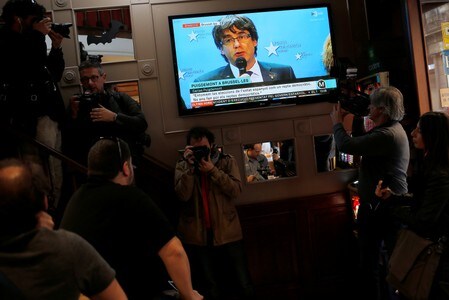１１月３日、スペイン高等裁判所は、カタルーニャ自治州のプチデモン前首相と同州の４人の前幹部に対する逮捕状を発行したことを明らかにした。５人とも現在はベルギーに滞在している。写真は１０月、 前首相の記者会見のニュースを放映するＴＶ。バルセロナで撮影（２０１７年　ロイター/Jon Nazca）