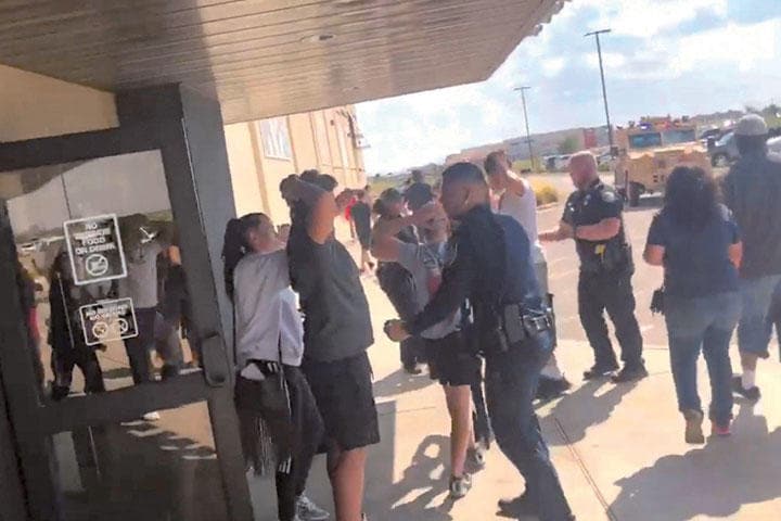 オデッサの映画館前で、捜査員がボディーチェックを行う　RICK LOBO VIA REUTERS