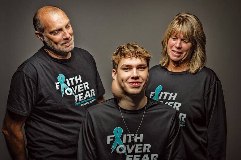 ゲイブ・アウグダール（中央）は希少疾患のデスモイド腫瘍の患者。家族と共にデスモイド腫瘍研究財団の資金集めとこの病気の広報活動に力を入れている。母親のサリーは同財団の理事　BOB CAREY/COURTESY FAITH OVER FEAR