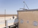 ジャルディ村の学校の屋上に立つ少年。シリア内戦で破壊された後の2013年、住民たちは村の中心部に共同の庭園兼菜園を整備した。収穫した農産物は近隣の市場で販売され、その収益は住民の共同基金に充てられている