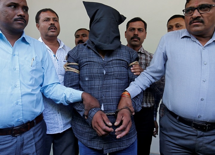 インド西部のアーメダバードで4月21日、11歳の少女をレイプし殺害したとして逮捕された容疑者（覆面の男）　Amit Dave-REUTERS